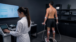 Atleta realizando exame de bioimpedância em clínica especializada, acompanhado por profissional de saúde, para avaliação da composição corporal e acompanhamento do desempenho físico.